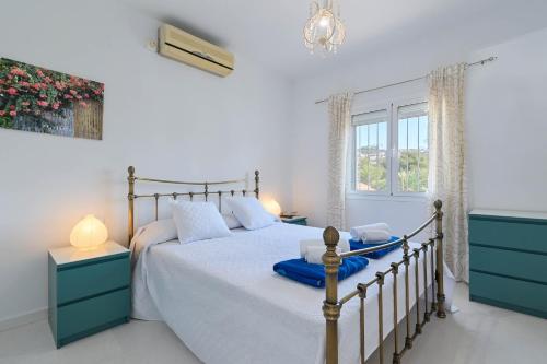 een slaapkamer met een bed met blauwe kasten en een raam bij Charlotte in Benissa