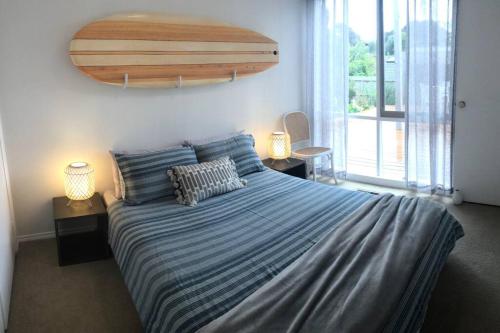 a bedroom with a large bed with blue striped sheets at 4 bedroom family holiday home with large deck in Blairgowrie