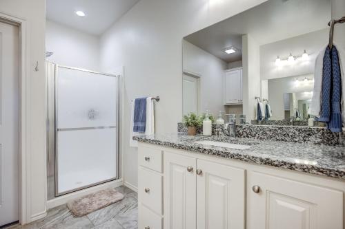 a white bathroom with a sink and a shower at Luxury Lubbock Home Retreat near Texas Tech in Lubbock