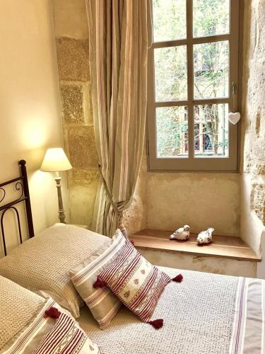 - une chambre avec un lit et une fenêtre avec deux animaux farcis dans l'établissement Walnut, à Sarlat-la-Canéda
