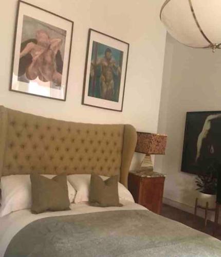 リバプールにあるLakeside View Arts and Craft Apartmentのベッドと壁に2枚の絵が飾られた寝室