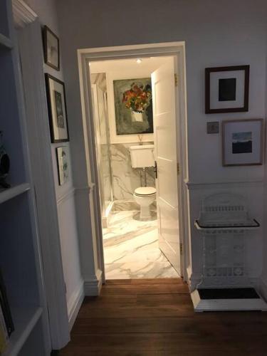 a hallway with a bathroom with a toilet in it at Lakeside View Arts and Craft Apartment in Liverpool