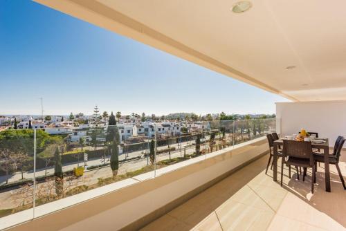 a balcony with a table and chairs and a view of a city at Aqua Apartments Vento, Marbella in Marbella