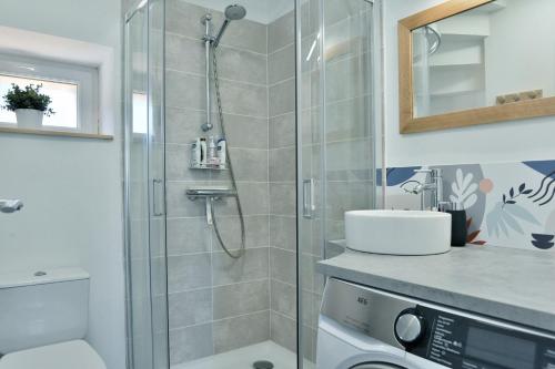 een badkamer met een douche, een toilet en een wastafel bij Ty Karet - Maison pour 6 proche plage in Saint-Cast-le-Guildo