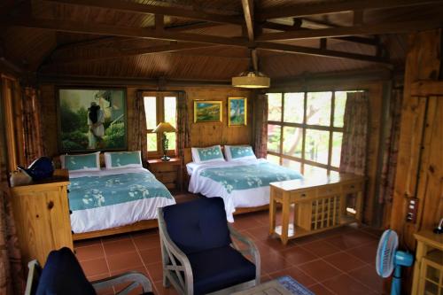 1 dormitorio con 2 camas y 1 silla en Zen Cafe Countryside Retreat 