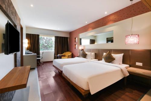 En eller flere senge i et værelse på 7 Apple Hotel Pimpri Pune
