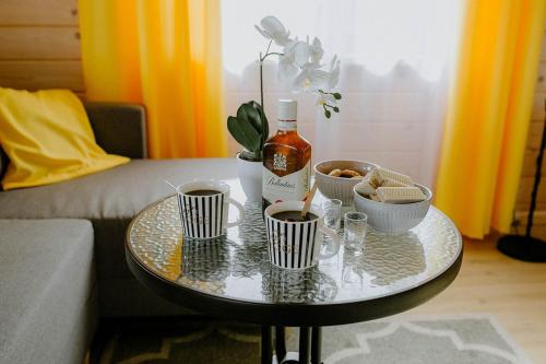 a coffee table with cups and a bottle of wine at Chata Krusznia in Giby