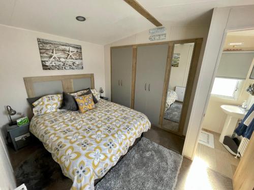 a bedroom with a large bed and a sink at Crandley Manor Lodge in Whitstable