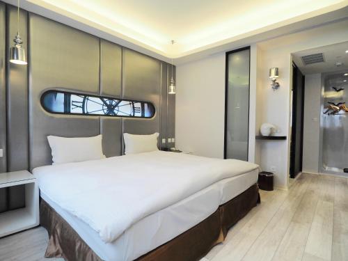 a bedroom with a large white bed with a window at Stay Hotel - Taichung Yizhong in Taichung