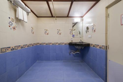 a bathroom with blue and white tiles and a sink at 7 Apple Hotel Pimpri Pune in Pune