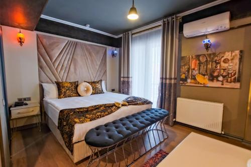 Dormitorio con cama con banco en MOONDAY HOTEL, en Kayseri