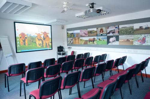 a conference room with chairs and a projection screen at Wold Escapes, Highfield Farm in Great Driffield
