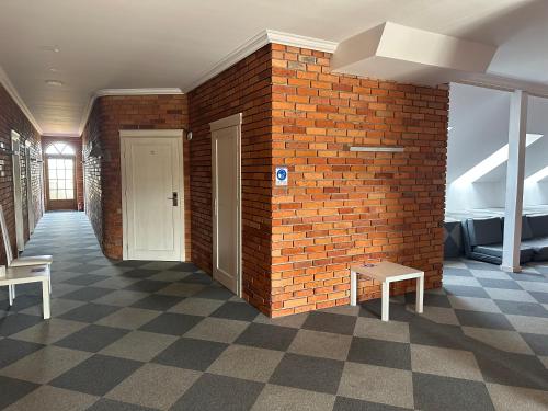 um quarto com uma parede de tijolos e dois bancos em Krzewi Róg em Garcz