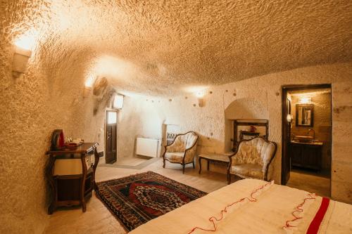 a bedroom with a bed and a table and chairs at Village Cave House Hotel in Goreme