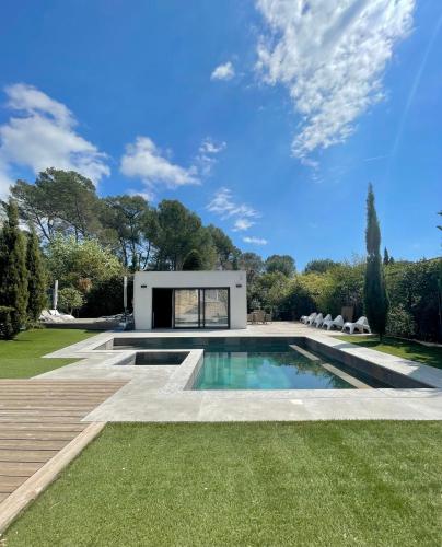 une piscine dans un jardin avec une maison dans l'établissement VILLA CALIFORNIENNE with Spa, cinema, jacuzzi & pool in Mougins, à Mougins