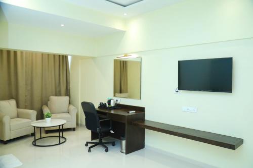 a room with a desk and a tv on a wall at Country Inn & Suites By Turtle in Mumbai