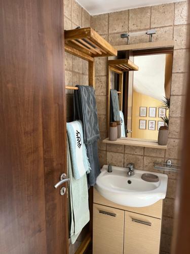 a bathroom with a sink and a mirror at GK Apartment in Chios