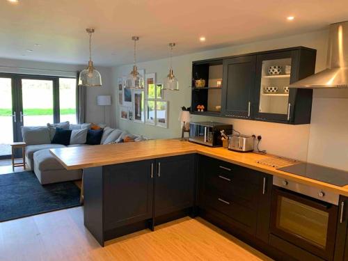 a kitchen with black cabinets and a living room at Ridgeway View in Pembrokeshire