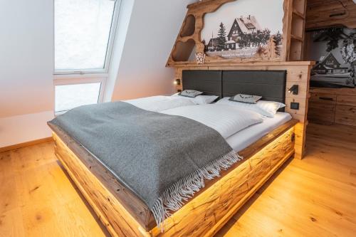 Cette chambre comprend un grand lit avec un cadre en bois. dans l'établissement Zugspitze Apartment Weit.Blick, à Kurort Altenberg