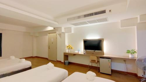 a hotel room with two beds and a flat screen tv at View Dee BKK Airport Residence in Ban Khlong Prawet
