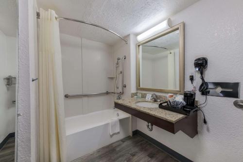 a bathroom with a sink and a tub and a mirror at Quality Inn & Suites Charlotte Airport in Charlotte