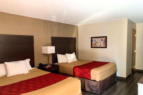 a hotel room with two beds with red sheets at Econo Lodge City Center in Portland