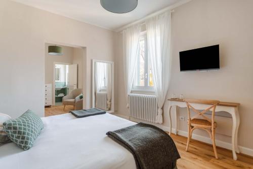 sypialnia z łóżkiem, biurkiem i telewizorem w obiekcie Villa Borgovecchio B&B w mieście Camaiore