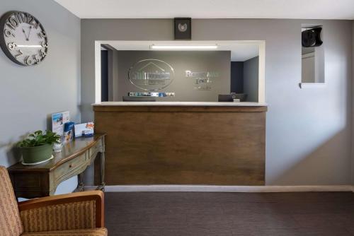 a bar in a waiting room with a clock on the wall at Suburban Studios Brazil in Brazil