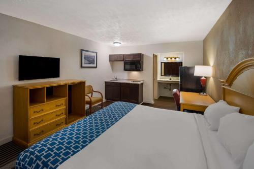 a hotel room with a bed and a television at Suburban Studios Brazil in Brazil