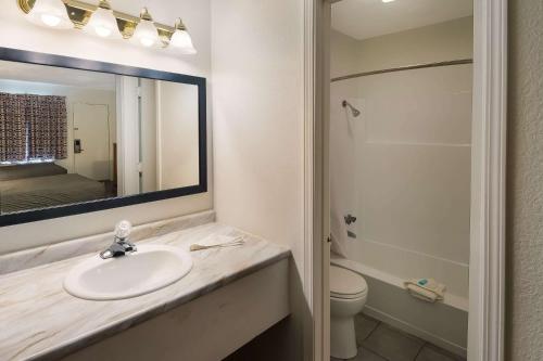 a bathroom with a sink and a toilet and a mirror at Suburban Studios Brazil in Brazil