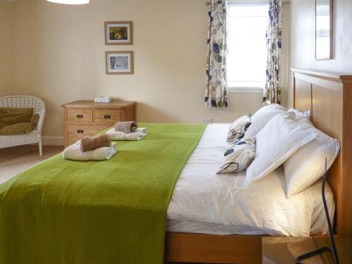 a bedroom with a large bed with two dogs laying on it at Kirkbride Farmhouse - 28471 in Creetown