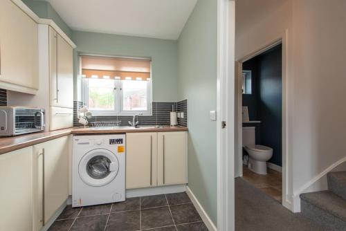 a kitchen with a washing machine and a sink at Grange Way in Bowburn
