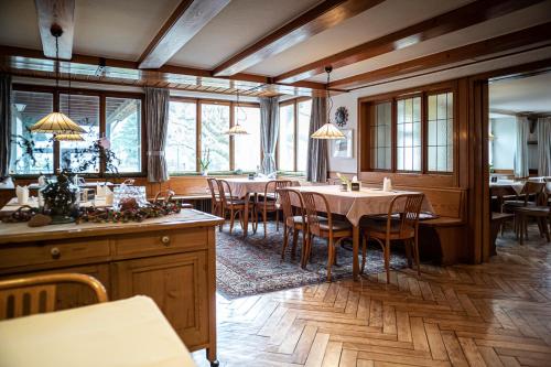 un comedor con mesas, sillas y ventanas en Gasthof Löwen Tosters en Feldkirch