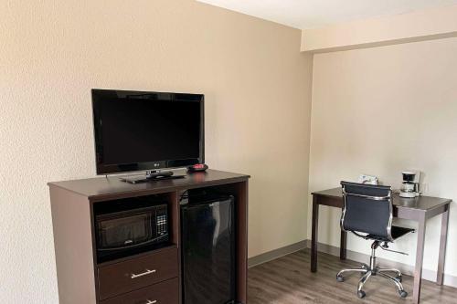 Cette chambre dispose d'une télévision, d'un bureau et d'une chaise. dans l'établissement Econo Lodge Vancouver, à Vancouver