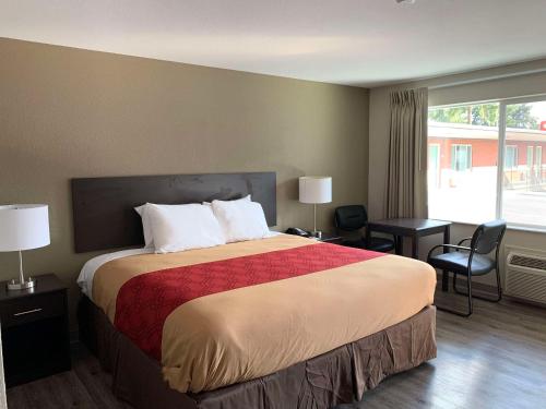 um quarto de hotel com uma cama e uma grande janela em Econo Lodge Vancouver em Vancouver