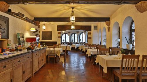 un restaurante con mesas y sillas en una habitación en Burg Windeck ***S, en Bühl