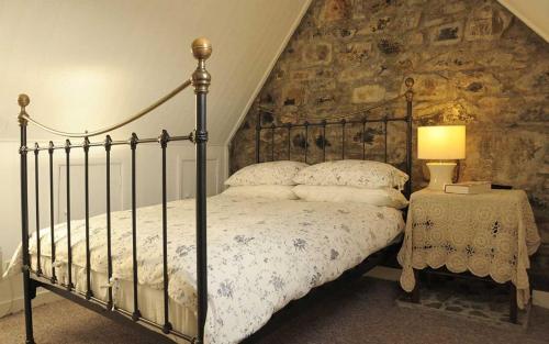 a bedroom with a bed and a stone wall at 21 Upper Edinbane in Edinbane