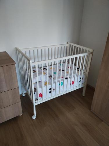a white crib with bottles in a room at Downtown penthouse Šabac in Šabac