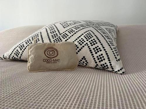 a pillow sitting on a bed with a black and white blanket at Athenian Zen in Athens