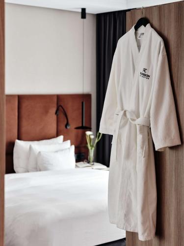 a robe hanging on a wall next to a bed at Radisson Collection Hotel, Warsaw in Warsaw