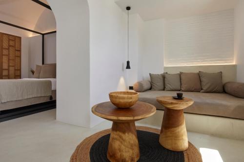 a living room with two tables in front of a couch at U & ME SUITES in Fira