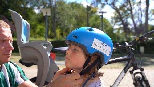 a little girl wearing a helmet and a man with a bike at AQUA HOUSE in Sopot