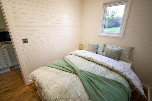 a bedroom with a bed and a window at 1-Bed pod cabin in beautiful surroundings Wrexham in Wrexham