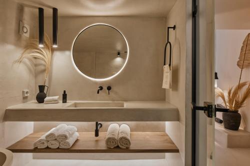 a bathroom with a sink and a mirror and towels at U & ME SUITES in Fira