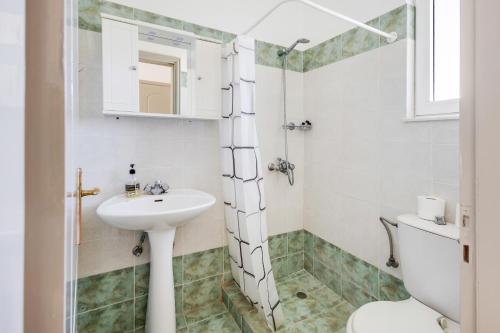 uma casa de banho com um lavatório e um WC em Johnhara Studios & Apartments em Ialyssos