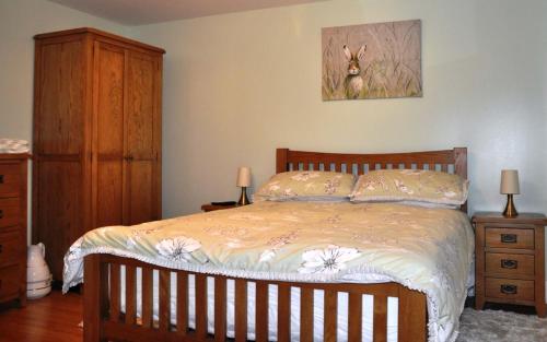a bedroom with a bed and a dresser at Fairy Glen Cottage in Uig