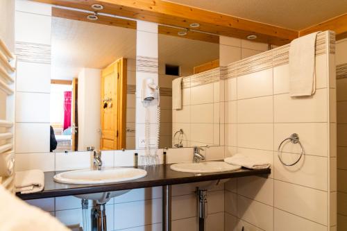 Baño con 2 lavabos y espejo en Golf du Rochat, en Les Rousses