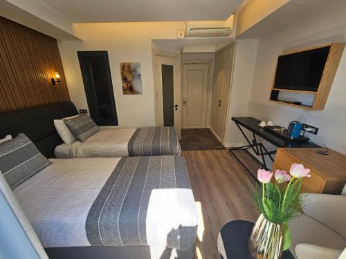 a hotel room with two beds and a desk at Anthemis Hotel in Istanbul