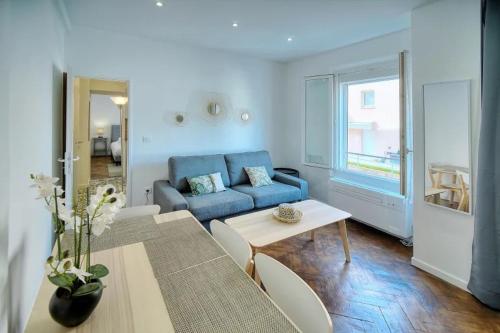 uma sala de estar com um sofá azul e uma mesa em LOENA CANNES CENTRE - Appartement rénové 2 pièces - 4 personnes - proche croisette palais festival plage - internet gratuit - climatisation - non fumeur em Cannes
