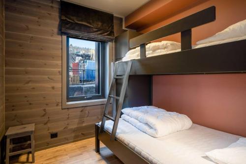 a bunk bed in a room with a ladder at Tiltalende og romslig leilighet in Beitostøl